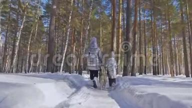 美丽的女人和<strong>小孩</strong>在<strong>冬天</strong>的森林里和哈士奇的狗散步。 快乐的年轻母亲和女儿
