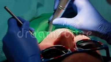 牙医和护士修理病人的牙齿。 用子钻牙，去除蛀牙
