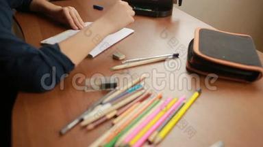 一个青少年在笔记本上画一支简单的铅笔。 特写