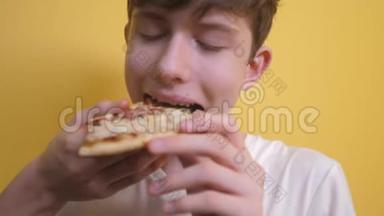 快乐的小男孩吃一片披萨的概念。 十几岁的男孩饥饿的生活方式吃一片披萨。 慢速视频