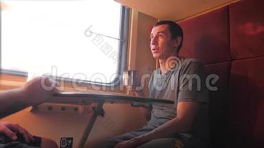 男人坐在火车车厢上，手里拿着智能手机铁路，喝着咖啡和茶。 <strong>慢生活</strong>方式<strong>慢生活</strong>方式