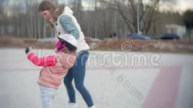妈妈和女儿<strong>骑</strong>着溜冰鞋。 女孩学习溜冰，摔倒。 妈妈教女儿<strong>骑</strong>车