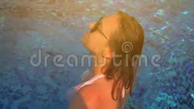 泳池里漂亮的女孩。 夏日的阳光。 慢动作