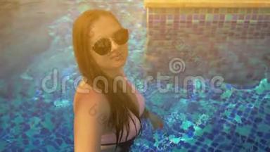 泳池里漂亮的女孩。 夏日的阳光。 慢动作
