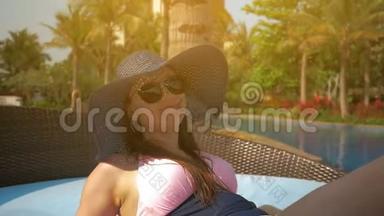游泳池边的休息室里戴着蓝色<strong>帽子</strong>的漂亮女孩。 <strong>夏日</strong>的阳光。