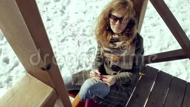 一个年轻的女人坐在木廊上，用手指默默地触摸折纸飞机，然后把它放在她的身上