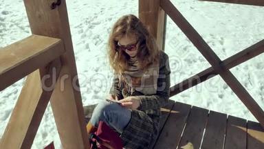 一个年轻的女人坐在木廊上，用手指<strong>默默</strong>地触摸折纸飞机，然后把它放在她的身上