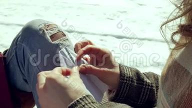 一个年轻的女人坐在木廊上，用手指<strong>默默</strong>地触摸折纸飞机，然后把它放在她的身上