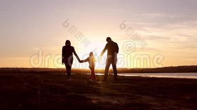 剪影，和爸爸妈妈一起快乐的孩子，日落时分的家人，夏天。 奔跑，在空中养育孩子，拥抱，爱，玩耍