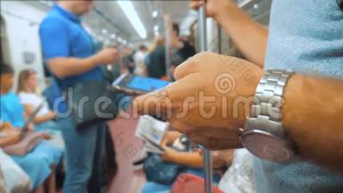 休闲男子从手机智能手机屏幕上阅读，同时看导航员在地铁上旅行。 慢慢慢慢