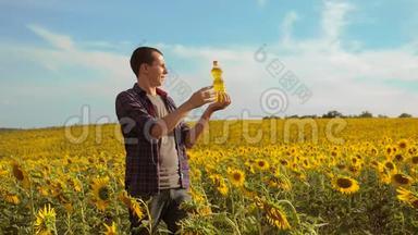 日落时分，农夫手捧一瓶葵花籽油. 农民农业塑料瓶葵
