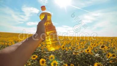 慢动作录像。 日落时分，农夫手捧一瓶葵花籽油. 。 农民生活方式农业
