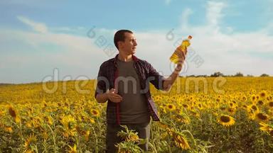 日落时分，农夫手里拿着一瓶向日葵的生活方式给田野加油。 慢动作视频。 农民农业