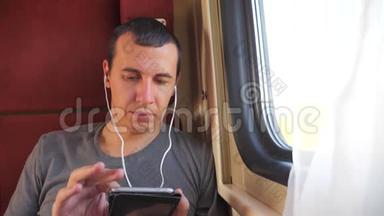 男子听音乐在火车上旅行，火车<strong>车厢车厢</strong>旅行。 慢动作视频。 一个男人