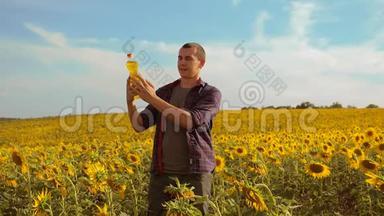 日落时分，农夫手捧一瓶葵花籽油的生活方式。 慢动作视频。 农民农业