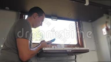 那人坐在火车车厢上，手里拿着智能手机，喝着咖啡和茶。 <strong>慢生活</strong>方式<strong>慢生活</strong>方式