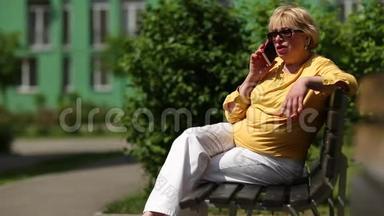 女人坐在长凳上，通过智能手机交流