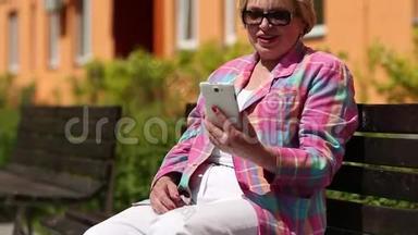 女人坐在长凳上，通过智能手机<strong>交流</strong>