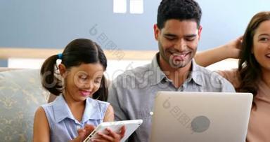 使用笔记本电脑、手机和数码平板电脑的幸福家庭