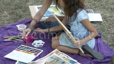 有女儿在公园里用水彩画画画的女人