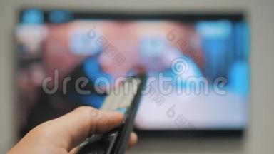 人手握电视遥控器，关掉智能电视。 频道冲浪。 把手举着电视遥控器