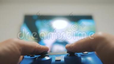 在电视上播放视频控制台。 手握新的操纵杆在电视上播放视频控制台。 玩家玩游戏游戏与游戏本