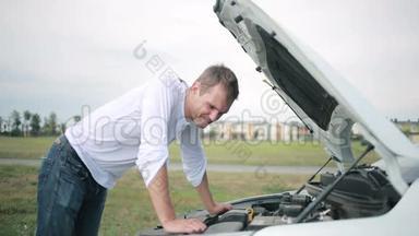 看着汽车发动机的人。 修理破车的人