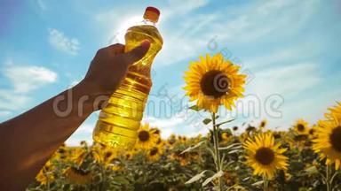 农夫手里拿着一瓶塑料<strong>葵花籽</strong>油，阳光洒在他的手里。 慢动作视频。 蓝天背景