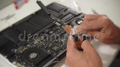 一个人正在修理<strong>笔记本</strong>电脑。 计算机修复的概念.. 用一个人修理<strong>笔记本</strong>电脑主板