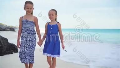 两个小妹妹在白色海滩上海边散步