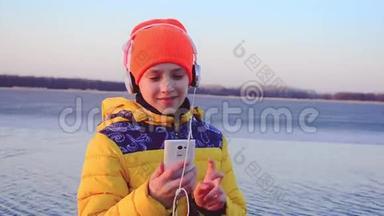 年轻女孩带着手机在耳机上听音乐，女孩带着耳机随着音乐跳舞。