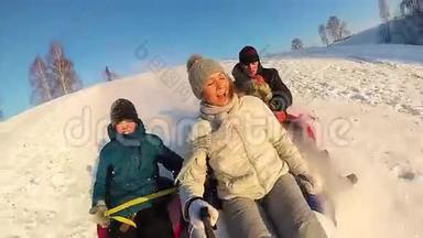 幸福的家庭乘坐和微笑的雪管在雪道上。慢动作。 冬天的雪景。 户外运动