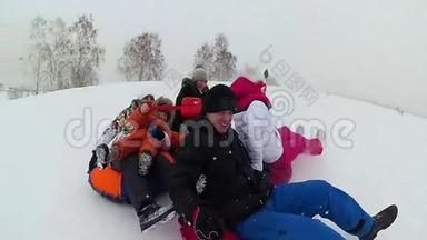 幸福的家庭乘坐和微笑的雪管在雪道上。 慢动作。 <strong>冬天</strong>的雪景。 <strong>户外运动</strong>