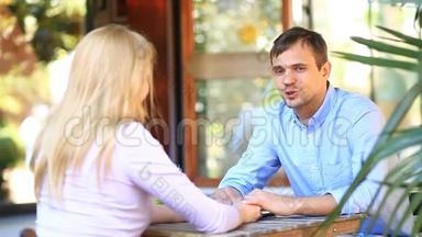 一对情侣在户外咖啡馆谈恋爱。 男人和美女约会