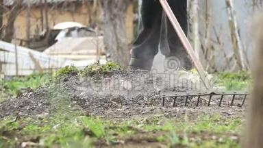 女人正在用<strong>耙子</strong>工具清理花园里的杂草。 慢动作