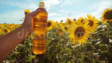农夫用向日葵在田野里探索。 农夫手里拿着一瓶塑料葵花籽油