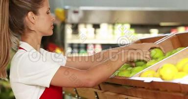 在超市里放水果的漂亮工人