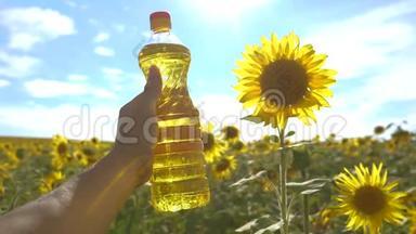 农夫手里拿着一瓶塑料葵花籽油，生活方式野外阳光。 慢动作视频。 农业