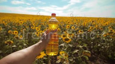 慢动作录像。 日落时分，农夫手捧一瓶葵花籽油. 。 农民农业塑料