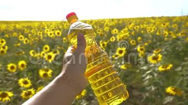 农夫手里拿着一瓶塑料<strong>葵花籽</strong>油，阳光洒在他的手里。 慢动作视频。 农业概念