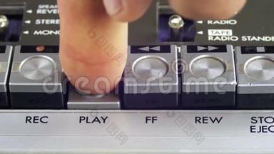 按下老式磁带录音机的播放和停止按钮