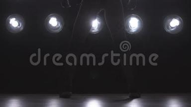 一个女孩在背景灯上跳舞的<strong>剪影</strong>。 慢动作