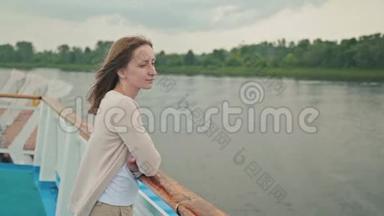 年轻漂亮的女人站在<strong><strong>游</strong>轮</strong>甲板上看着河。
