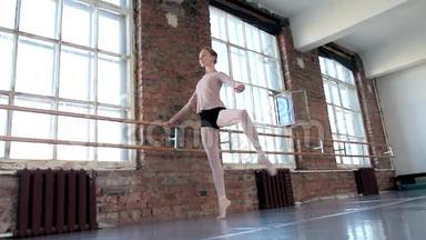 年轻的女芭蕾舞演员在芭蕾舞班锻炼