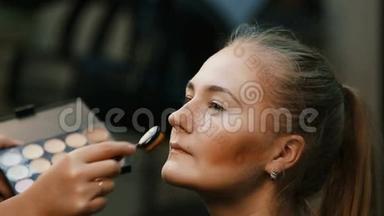 化妆师做职业化妆年轻女人。