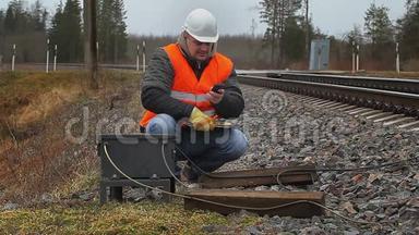 铁路员工在铁路附近使用手机