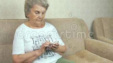 <strong>家中</strong>拿着手机的老年妇女