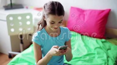 微笑的女孩在家里用智能手机发短信
