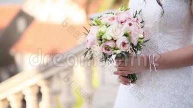 新娘手中的婚礼玫瑰和牡丹。 婚礼