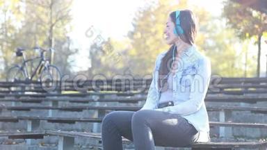 公园里戴着耳机听音乐的美女